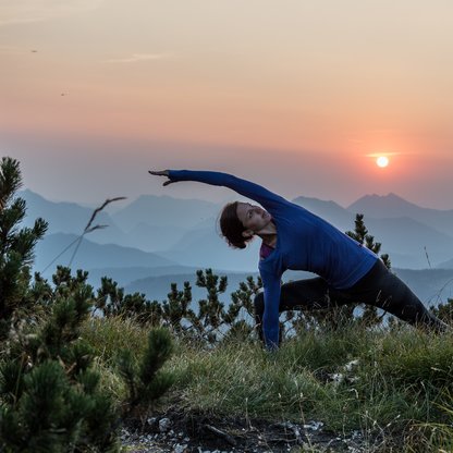 Yogaeinheit bei Sonnenuntergang auf den Gipfeln in der Wanderregion Kössen